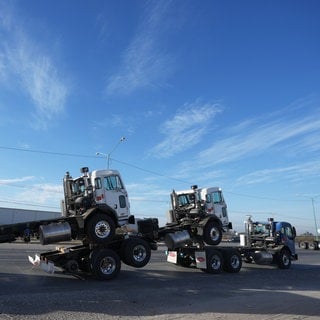 Ein Lastwagen zieht mehrere frisch montierte LKW-Fahrerhäuser über die Grenze von Mexiko in die USA.