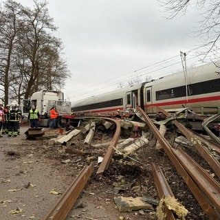 Rettungskräfte arbeiten an der Unfallstelle. In Hamburg ist ein ICE gegen einen Sattelzug gefahren.