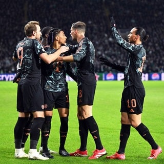 Champions League, Celtic Glasgow - Bayern München, K.o.-Runde, Zwischenrunde, Hinspiele, Celtic Park, Münchens Michael Olise (2.v.l) jubelt mit den Teamkollegen Harry Kane (l-r), Leon Goretzka, Leroy Sané und Konrad Laimer nach seinem Treffer zum 0:1.