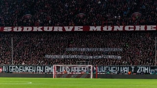 UEFA Champions League: FC Bayern München - Celtic FC; 18.02.2025 Gedenkminute für die Opfer des Anschlags in München Banner in der Südkurve Bestürzt, in tiefer Trauer und gegen die gesellschaftliche Spaltung In Gedenken an Amel und Hafsa - München hält zam!