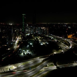 Während eines Stromausfalls in Chile fahren Autos an dunklen Gebäuden vorbei.