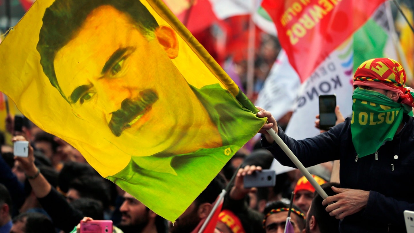 Ein Jugendlicher hält eine Fahne mit dem Bild des inhaftierten Anführers der verbotenen kurdischen Arbeiterpartei PKK, Öcalan. Öcalan hat seine Anhänger dazu aufgerufen, die Waffen niederzulegen.