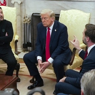 US-Vizepräsident JD Vance (r) spricht mit dem ukrainischen Präsidenten Wolodymyr Selenskyj (l) im Beisein von US-Präsident Donald Trump (M) im Oval Office des Weißen Hauses.