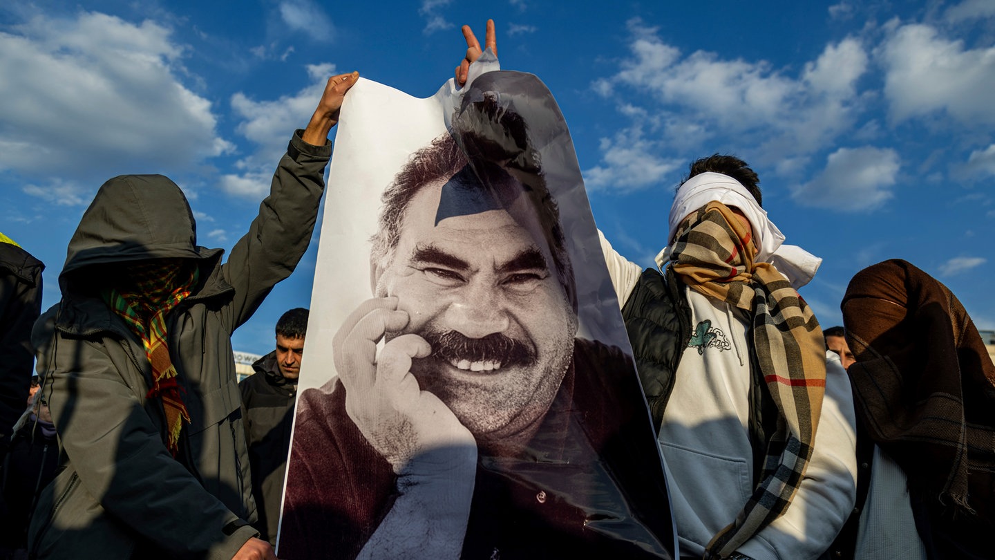 Jugendliche halten ein Plakat des inhaftierten Anführers der Arbeiterpartei Kurdistans (PKK), Öcalan, während sie live auf einem Fernsehbildschirm mitverfolgen, wie Mitglieder einer prokurdischen Delegation der Partei für Gleichheit und Demokratie (DEM) eine Erklärung von Öcalan veröffentlichen.