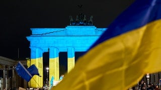 Das Brandenburger Tor wird vor einer Gedenkveranstaltung zum dritten Jahrestag des russischen Angriffs auf die Ukraine in den ukrainischen Nationalfarben angestrahlt.