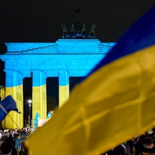 Das Brandenburger Tor wird vor einer Gedenkveranstaltung zum dritten Jahrestag des russischen Angriffs auf die Ukraine in den ukrainischen Nationalfarben angestrahlt.