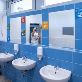 Symbolbild: Eine Schultoilette mit Waschbecken und Spiegeln. Ein Schulleiter in England hat an seiner Schule alle Spiegel in den Toiletten abhängen lassen. Gute Idee oder No-Go?