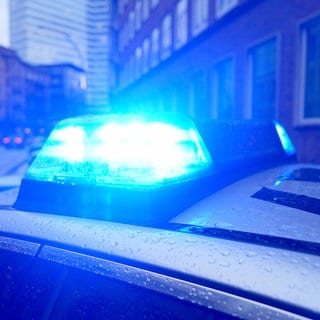 Ein Blaulicht leuchtet auf dem Dach eines Polizeiautos - In Kirchheim unter Teck wurde eine Frau mit einem Messer verletzt. Der Verdächtige ist auf der Flucht.