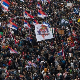 Demonstranten schwenken serbische Fahnen und versammeln sich in der Nähe des serbischen Parlaments. In der serbischen Hauptstadt Belgrad haben am Samstag Zehntausende Menschen gegen die Regierung um Präsident Aleksander Vucic und gegen Korruption im Land protestiert.