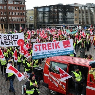 Teilnehmerinnen und Teilnehmer eines Warnstreiks verschiedener Gewerkschaften laufen in einem Demonstrationszug durch die Innenstadt zum Rathaus in Kiel.